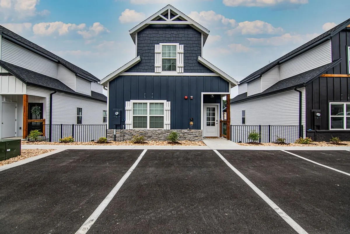 A front view of the house features blue and white siding, stone accents, and an inviting front porch. The view suggests a friendly, safe neighborhood ideal for walks with dogs.
